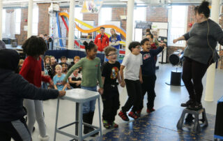 A group of students engage in a static electricity demonstration.