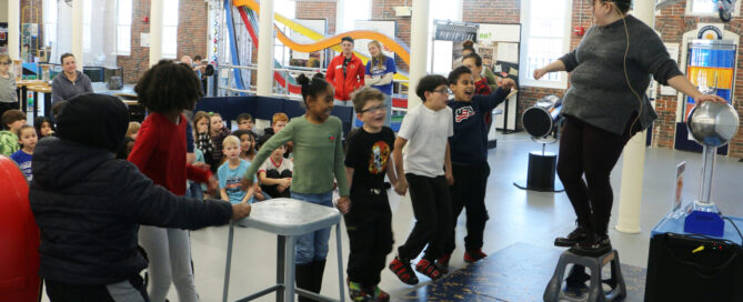 A group of students engage in a static electricity demonstration.