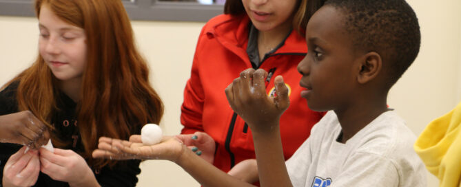 a boy shows silly putty he made in the lab.