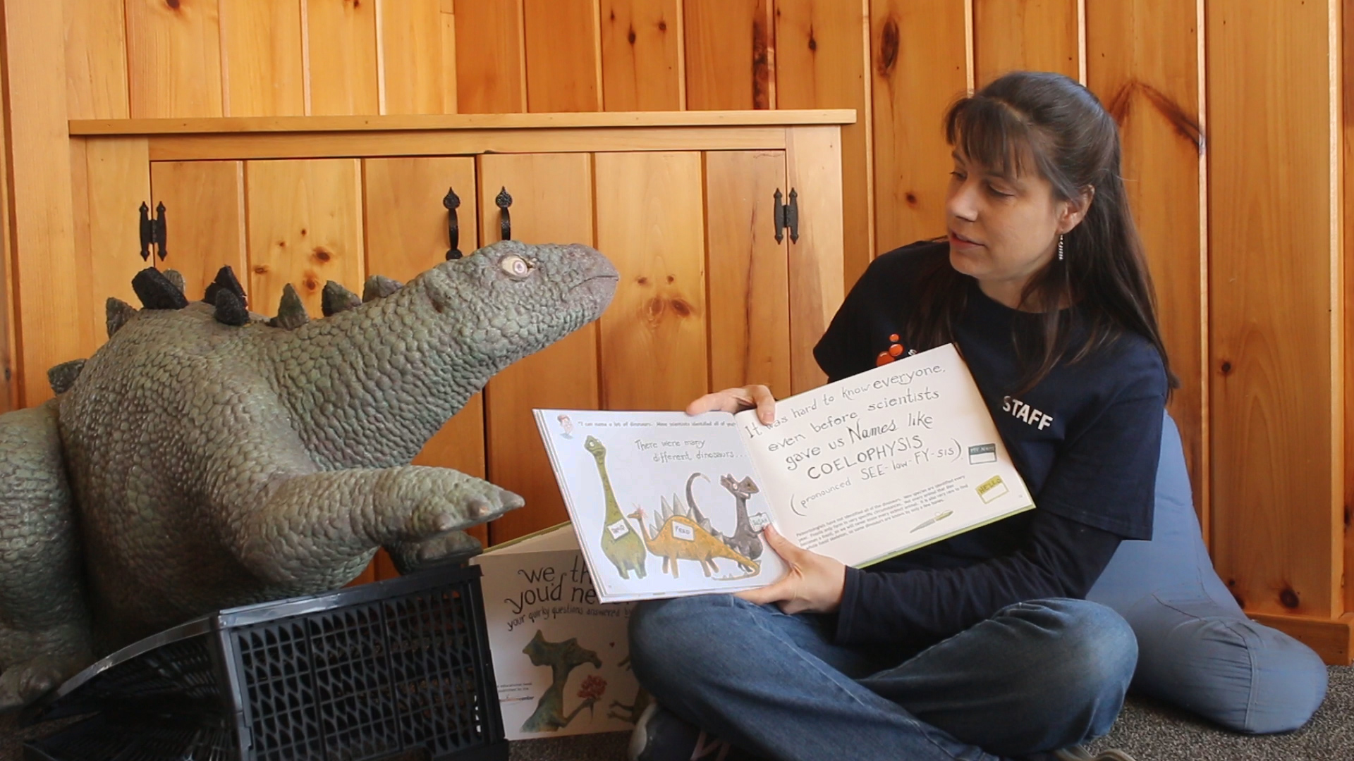Woman holding book with dinosaur