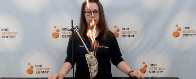 A SEE educator lights a dollar bill on fire but it is not consumed.