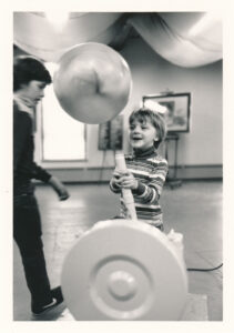 a young boy watches a ball float in the air at a bernoulli blower exhibit.
