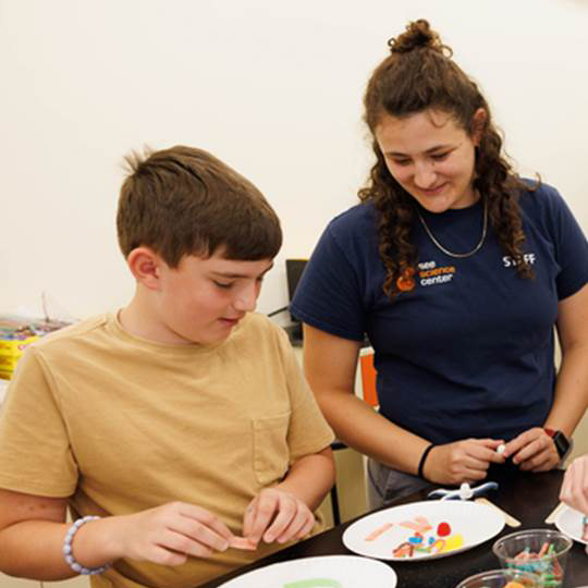 a camper and couselor work on an a model