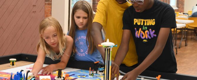Campers use robots to complete challenges on a playing field