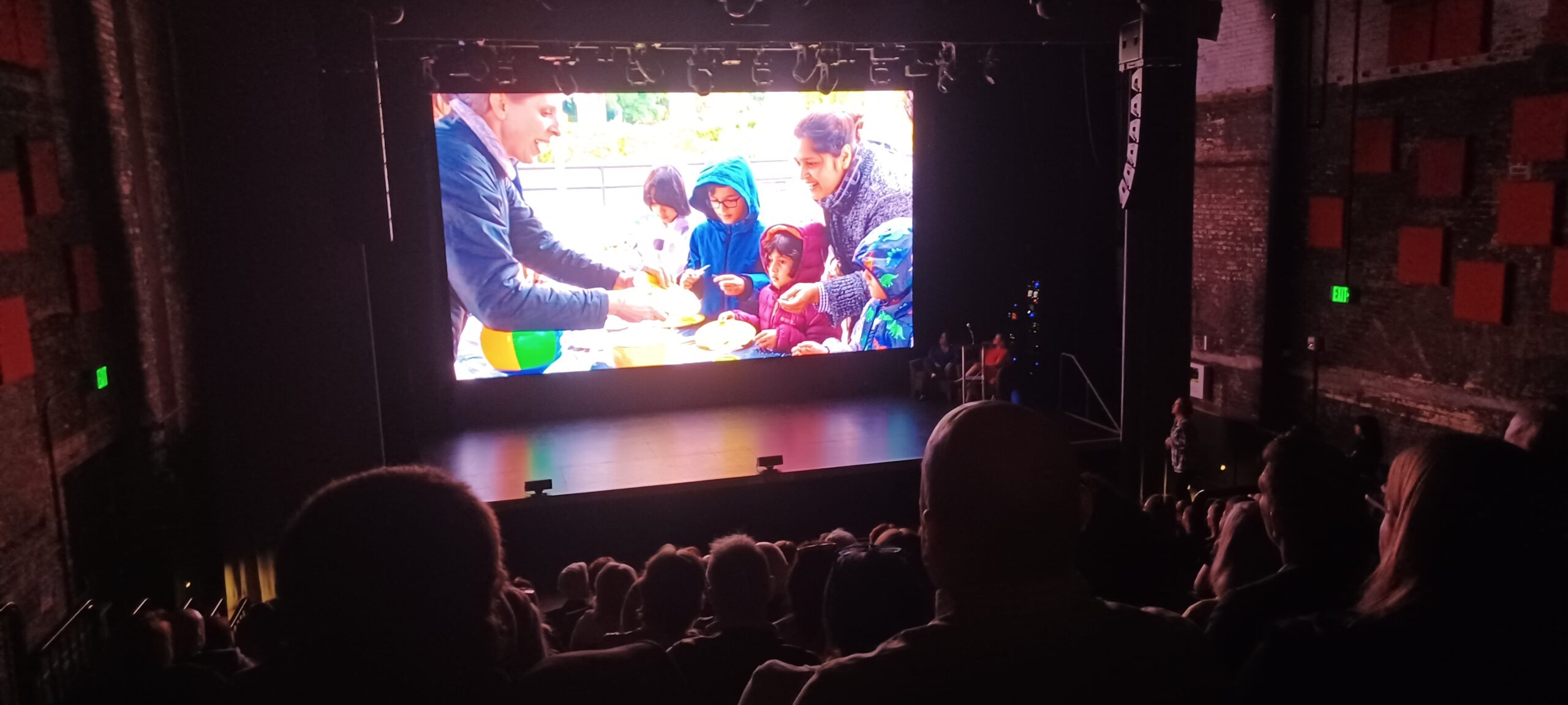 image of Shana interacting with a family on screen at the event