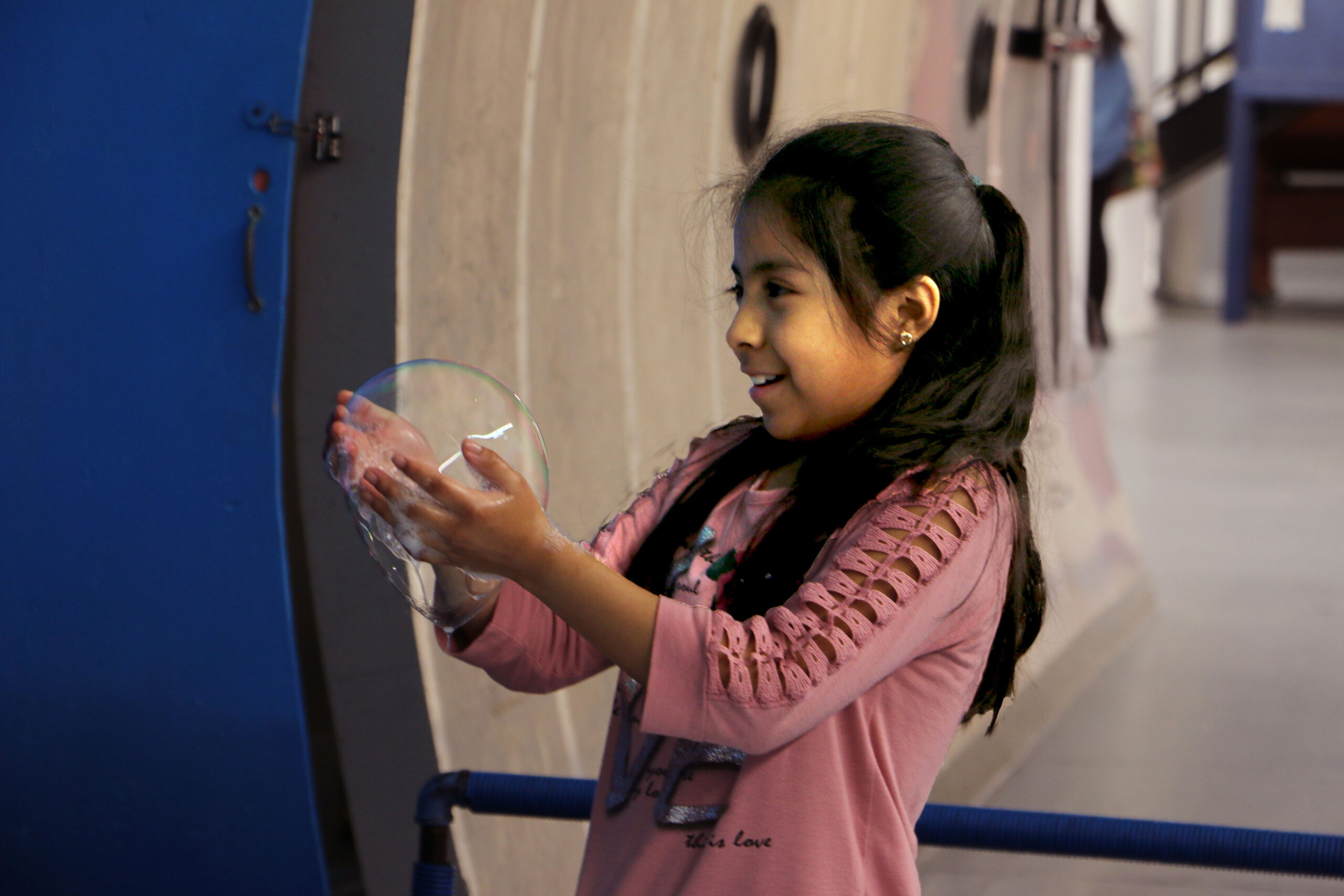 a girl holds a bubble in her hands at SEE