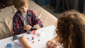 A young boy does an experiment while an adult assists