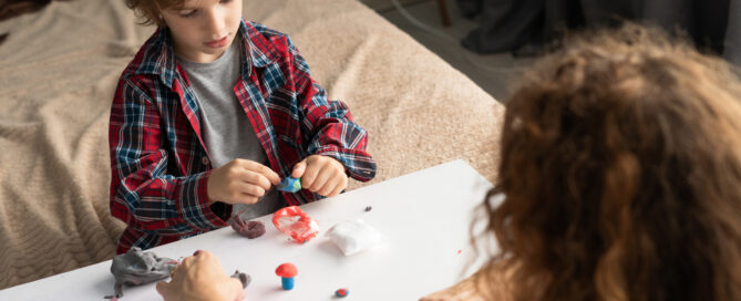 A young boy does an experiment while an adult assists