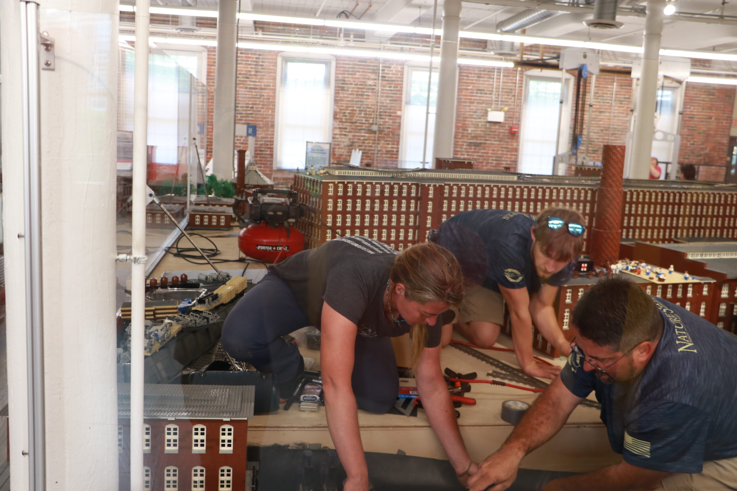 three people bent down and working in the river in the LEGO Millyard Model