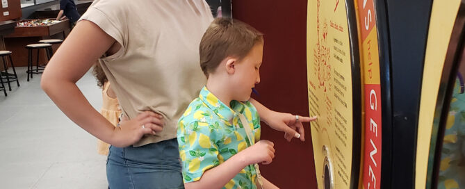 A young boy carrying a communications tablet engages with an exhibit at SEE.