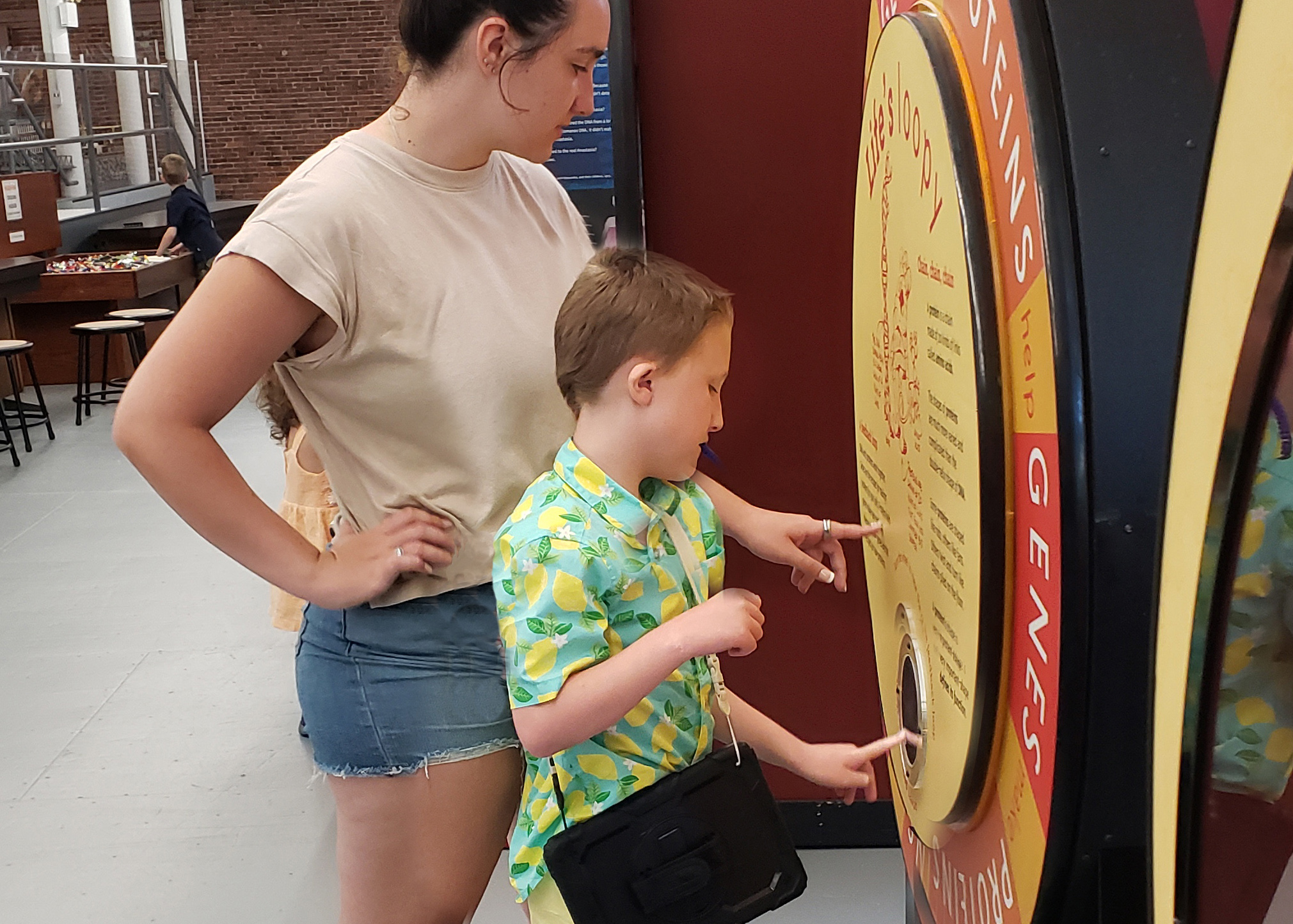 A young boy carrying a communications tablet engages with an exhibit at SEE.