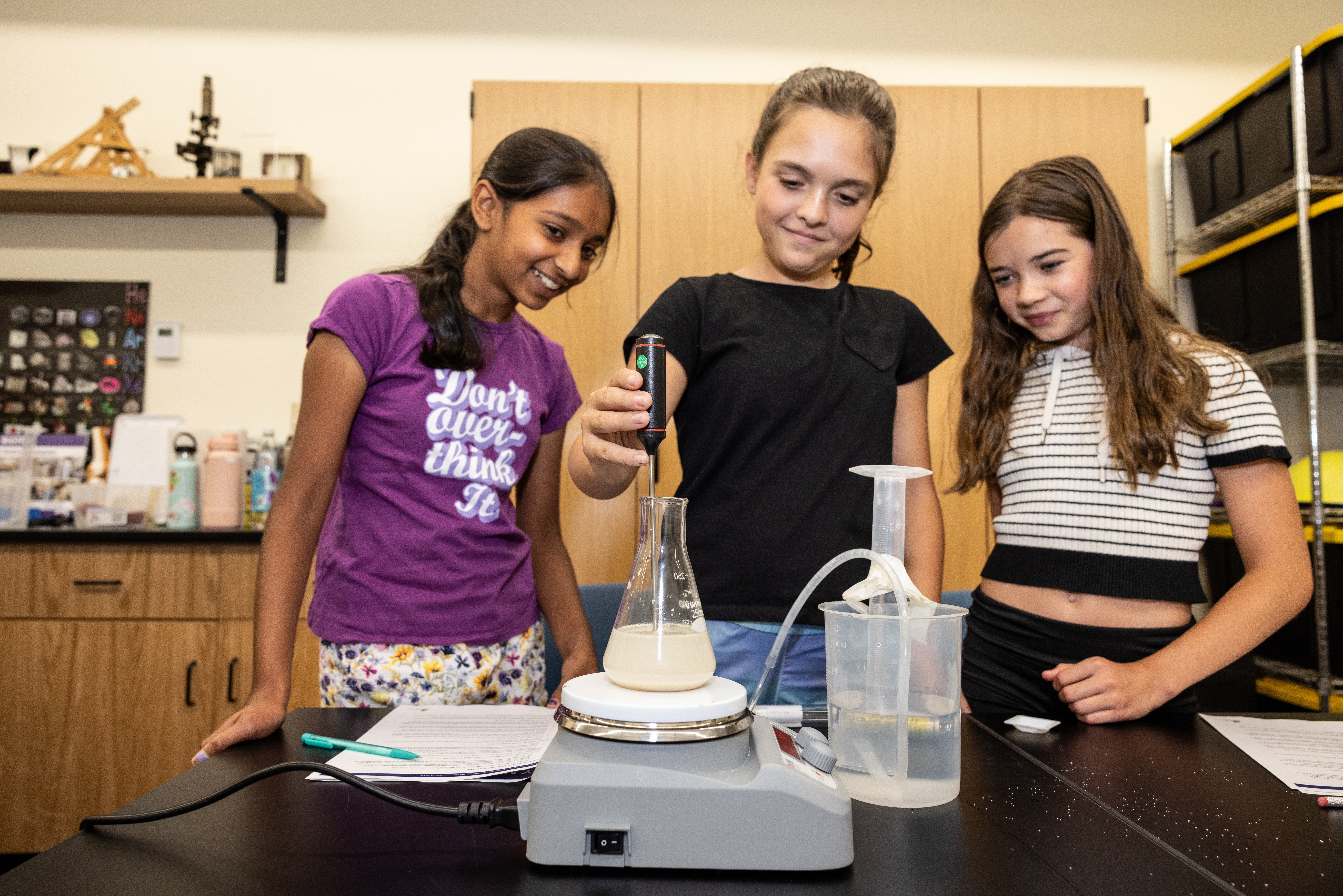 Three Girls work on a lab experiment at a camp at SEE