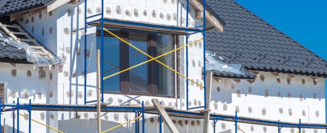 A house under construction with exterior insu lation and scaffolding