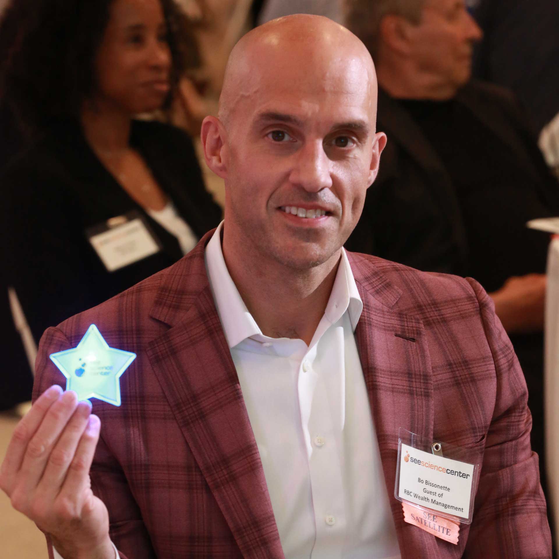 a donor holding up his lighted star button